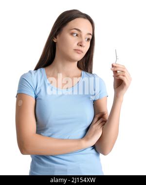 Jeune femme avec timbre de nicotine appliqué et cigarette cassée sur fond blanc. Cesser de fumer Banque D'Images