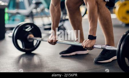 Portrait d'un athlète masculin méconnaissable en travaillant avec Barbell à la salle de gym Banque D'Images