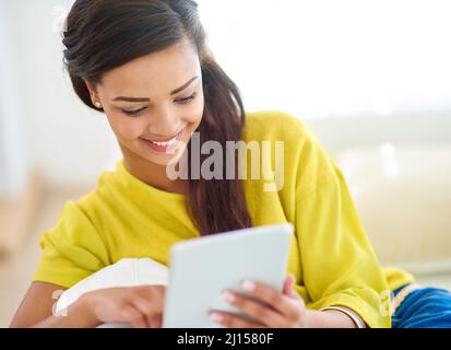 Profitez des vibes du week-end. Prise de vue d'une jeune femme utilisant une tablette numérique à la maison. Banque D'Images