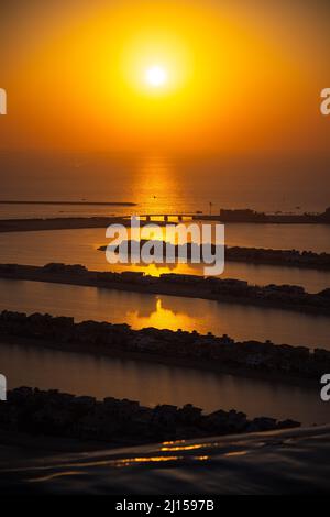 Magnifique coucher de soleil doré avec un panorama sur le Palm Jumeirah Dubai, tourné depuis le bord d'une piscine à débordement ; le plus beau papier peint de coucher de soleil Banque D'Images