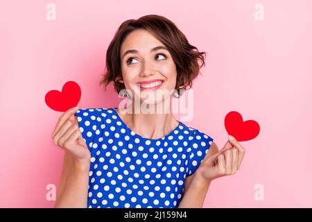 Photo de hooray jeune brune dame tenir les coeurs look promo porter blouse bleue isolée sur fond rose couleur Banque D'Images