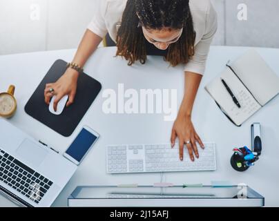 Entièrement focalisé. Aucune distraction. Photo en grand angle d'une jeune femme d'affaires travaillant à son bureau. Banque D'Images