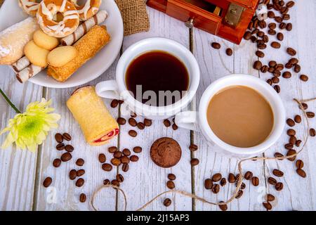 deux tasses de café, lait noir et blanc, moulin à café, biscuits et grains de café Banque D'Images