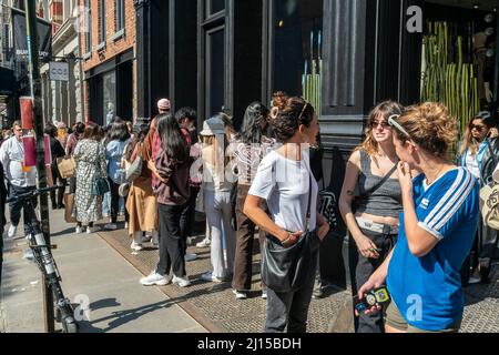 Les plus tendance fêtent le temps chaud et insatisfaisant en attendant des heures en file d'attente devant le magasin Valentino de Soho à New York samedi. Le 19 mars 2022 pour participer à l'activation de la marque Valentino et présenter sa collection rendez-vous. En plus d’avoir la possibilité d’acheter la marchandise du concepteur, les participants ont connu des fleurs gratuites, une voiturette à café et plus encore. (© Richard B. Levine) Banque D'Images