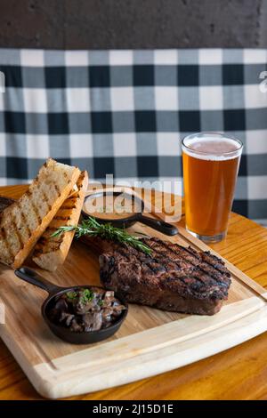 Food Tomahawk steak - ribeye - avec de la sauce aux champignons et du pain avec une bière pression dans un pub d'Arlington Virginia appelé le Pinemoor Banque D'Images