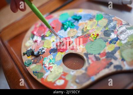 Mélange de peinture rouge sur un tableau. Banque D'Images