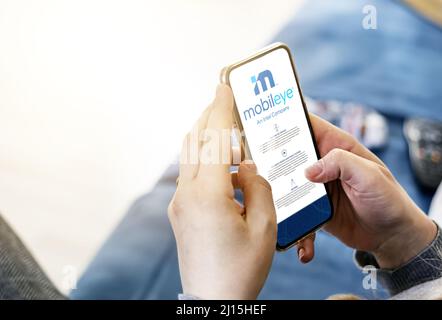 Jerusalem, ISR, mars 2022 : une femme naviguant sur son téléphone sur le site Web de la société Mobileye. Rédactionnel. Maquette réaliste. Mise au point sélective. Banque D'Images