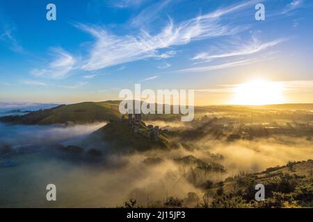 Vue aérienne sur les nuages flottants et le soleil qui brille sur le château de Corfe en Angleterre Banque D'Images