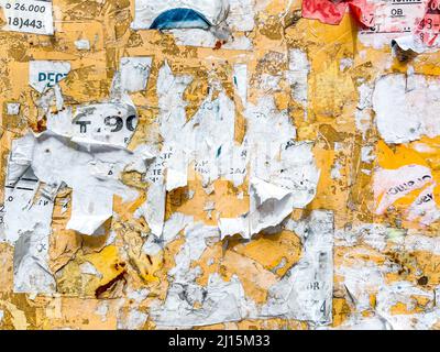 Panneau d'affichage extérieur ou panneau de contreplaqué avec message publicitaire usé, avis et autocollants texture de rue Banque D'Images