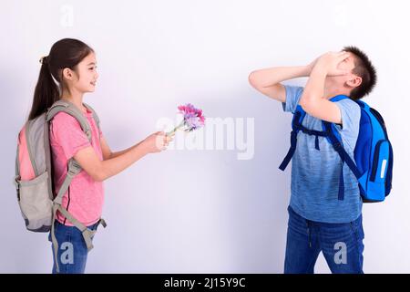 Fille donne à garçon un bouquet de fleurs Banque D'Images