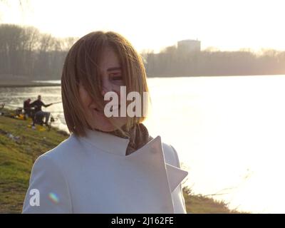femme élégante caucasienne senior au coucher du soleil à l'extérieur dans un parc au début du printemps Banque D'Images