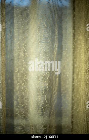 Rideaux en plein soleil. Rideaux sur la fenêtre. Le tissu brille à travers. Texture de maillage fin. Banque D'Images