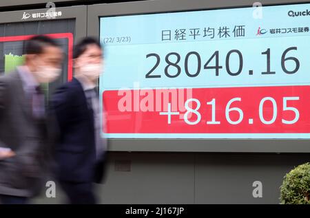 Tokyo, Japon. 23rd mars 2022. Les piétons passent devant un tableau des prix des actions à Tokyo le mercredi 23 mars 2022. Le cours des actions japonaises a bondi de 816,05 yens pour se fermer à 28 040,16 yens à la Bourse de Tokyo. Credit: Yoshio Tsunoda/AFLO/Alay Live News Banque D'Images