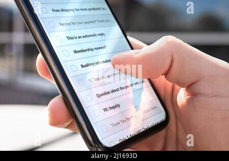 Boîte de réception de courriel dans le téléphone à l'extérieur. Liste des nouveaux messages non lus ou des courriers indésirables. Bulletins d'information marketing. Homme regardant le compte de postes mobiles numériques. Banque D'Images