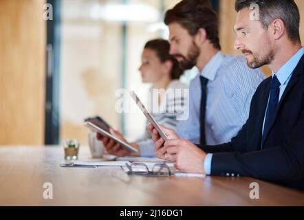 Toutes les mains sur le pont pour la présentation. Prise de vue de personnes en voyage d'affaires utilisant leur tablette numérique lors d'une conférence. Banque D'Images