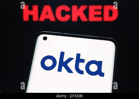 Logo de la société de sécurité Okta visible sur le smartphone et le mot PIRATÉ sur un arrière-plan flou. Concept de hack. Stafford, Royaume-Uni, 22 mars 2022. Banque D'Images