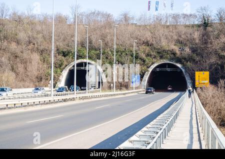 Novi Sad, Serbie. Mars - 16. 2021. Tunnel au bout du pont Liberty avec des voitures et des panneaux de signalisation sous la partie de la montagne Fruska gora. Éditorial Banque D'Images