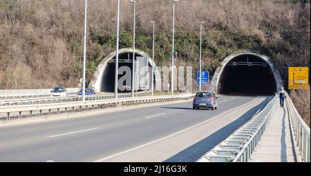 Novi Sad, Serbie. Mars - 16. 2021. Tunnel au bout du pont Liberty avec des voitures et des panneaux de signalisation sous la partie de la montagne Fruska gora. Éditorial Banque D'Images