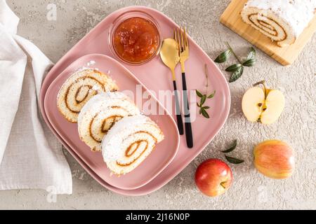 trois morceaux de gâteau maison aux pommes sont servis sur une assiette en céramique rose et un plateau en dessert, en-cas. vue sur le dessus. fond gris Banque D'Images