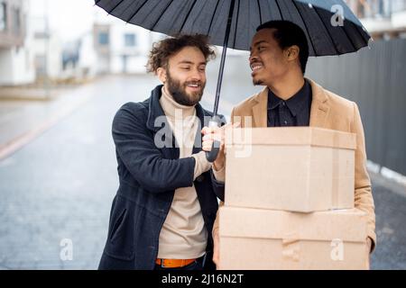 Couple gay marchant ensemble avec des colis à l'extérieur Banque D'Images
