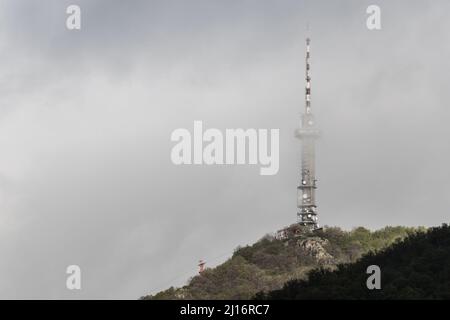 Tour de radio dans les nuages sur une haute colline Banque D'Images