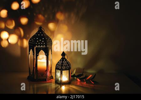 Lanternes décoratives en arabe avec bougies allumées la nuit. Lumières en bokeh dorées étincelantes. Carte de vœux de fête, invitation. Ramadan, le mois Saint des musulmans Banque D'Images