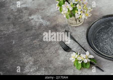 Table de printemps avec branches de pommier en fleur et fleurs sur table grise. Décoration de vacances de style provençal. Dîner romantique. Plus de Banque D'Images