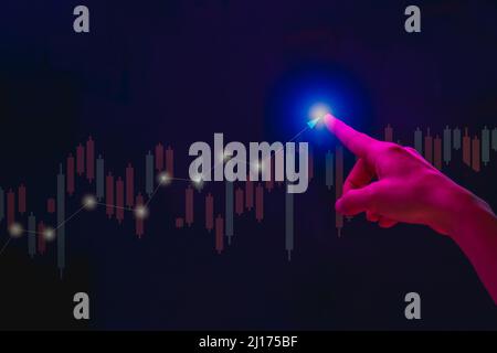 Homme d'affaires utilisant un graphique et un graphique de stock de symbole tactile sur un écran virtuel. Banque D'Images