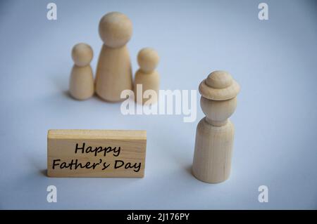 Le jour du père heureux souhaite texte sur bloc de bois avec maquette de poupée en bois d'un père et d'une famille. Concept de la fête des pères heureuse Banque D'Images