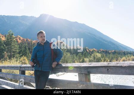 L'Autriche, les Alpes, l'homme en randonnée debout sur un pont avec des jumelles Banque D'Images