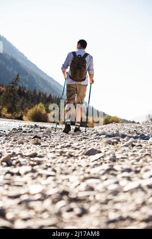 L'Autriche, les Alpes, l'homme en randonnée marche sur des cailloux le long d'un ruisseau Banque D'Images