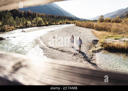 L'Autriche, les Alpes, en couple en randonnée marche le long d'un ruisseau Banque D'Images