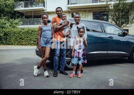 Famille debout devant la voiture sur la route Banque D'Images