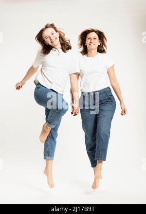 Mère et fille joueurs sautant en studio Banque D'Images