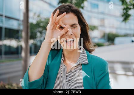 Bonne femme d'affaires en chic décontracté faisant signe ok geste avec la main Banque D'Images