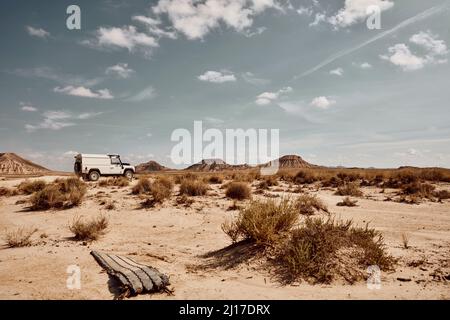 Voiture passant par la route dans la zone désertique de Bardenas Reales, Espagne Banque D'Images