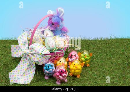 Panier de Pâques rempli d'œufs décorés avec des petits lapins et du poulet et des canards remplis de bonbons. Banque D'Images