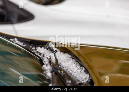 petites boules de glace sur le capot de voiture marron après une tempête d'été intense Banque D'Images