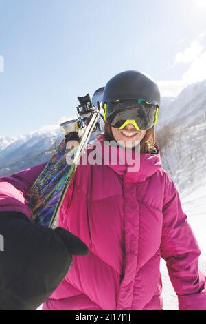 Homme heureux portant des skis sur l'épaule en hiver Banque D'Images