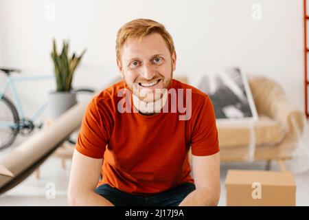 Happy young man sitting at home Banque D'Images