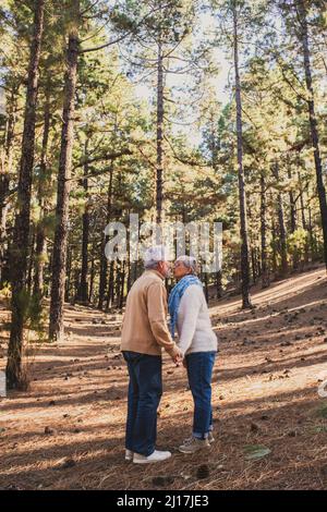 Couple senior s'embrassant dans la forêt Banque D'Images