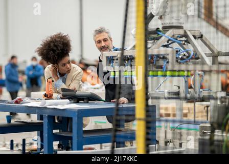 Ingénieurs examinant les machines en usine Banque D'Images