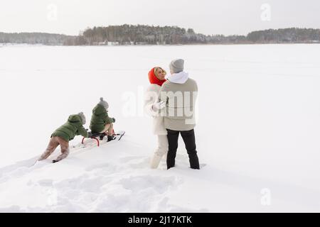 Couple embrassant les uns les autres par des fils qui se sont enlisés sur la neige en hiver Banque D'Images