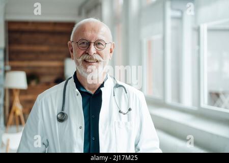 Médecin souriant portant un stéthoscope et des lunettes à l'hôpital Banque D'Images