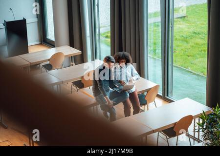 Collègues professionnels discutant sur ordinateur portable au travail Banque D'Images