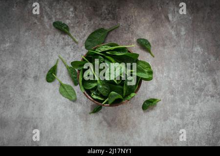 Feuilles d'épinards frais dans un bol. Vue de dessus des feuilles de vert biologique foncé. Concept de mode de vie alimentaire végétalien sain Banque D'Images