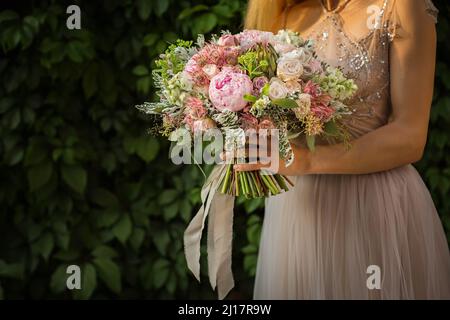 Portrait d'une jolie femme élégante et méconnue portant une robe de mariage grise Banque D'Images