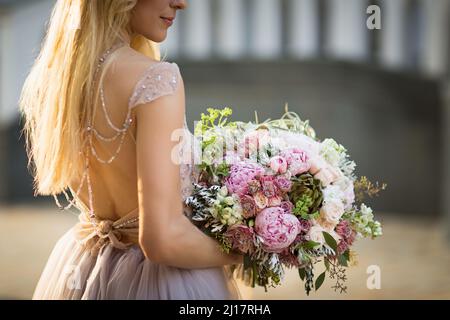 Portrait d'une jolie femme élégante et méconnue portant une robe de mariage grise Banque D'Images