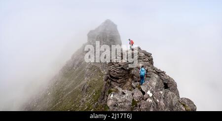 Homme et femme marchant sur le sommet de la montagne rocheuse Banque D'Images