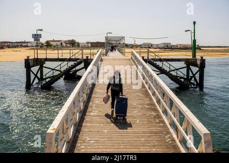 Un homme avec des sacs sur la jetée sur l'île de Culatra, Faro, Algarve, Portugal Banque D'Images